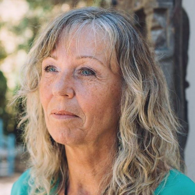 Kvinne med halvlangt hår og turkis genser